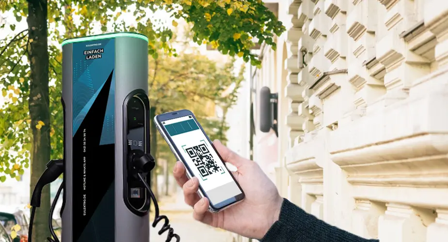 Hand mit Smartphone scannt den QR-Code an einer Ladesäule